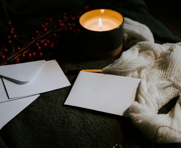 a candle and envelopes on a table